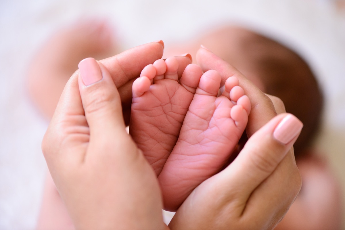 Babyfüße in den Händen der Mutter